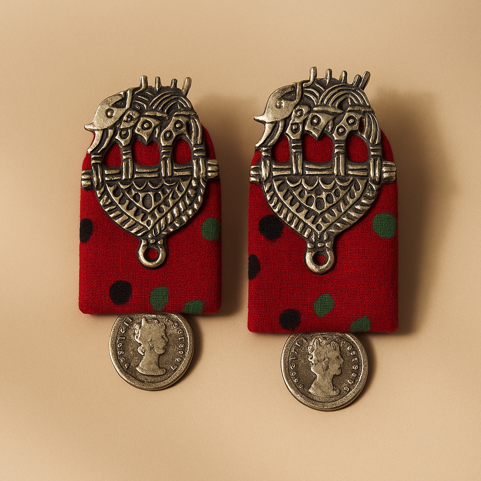Pair of Red Cloth earrings with red fabric backing and Antique silver metalwork on a beige background