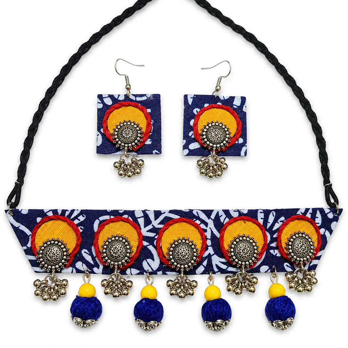 A matching jewelry set featuring a braided black neck strap, a navy blue patterned choker necklace, and a pair of square drop earrings, all decorated with colorful circular motifs in orange, red, yellow, and blue with silver-toned dangling charms.