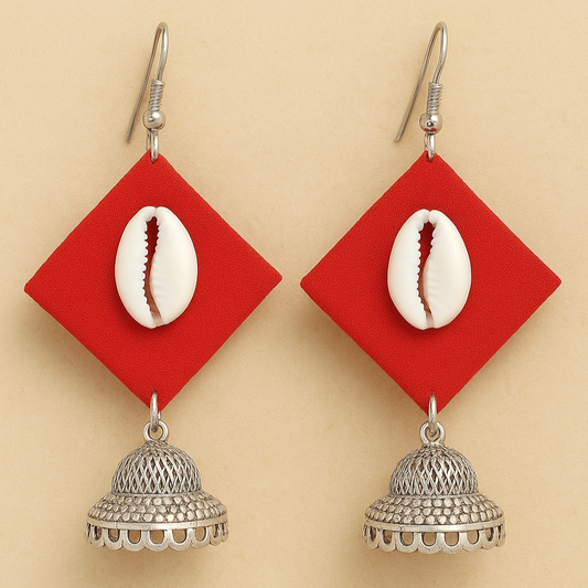 Fabric Earrings with red geometric pendants, cowrie shells, and silver jhumkas on a beige background