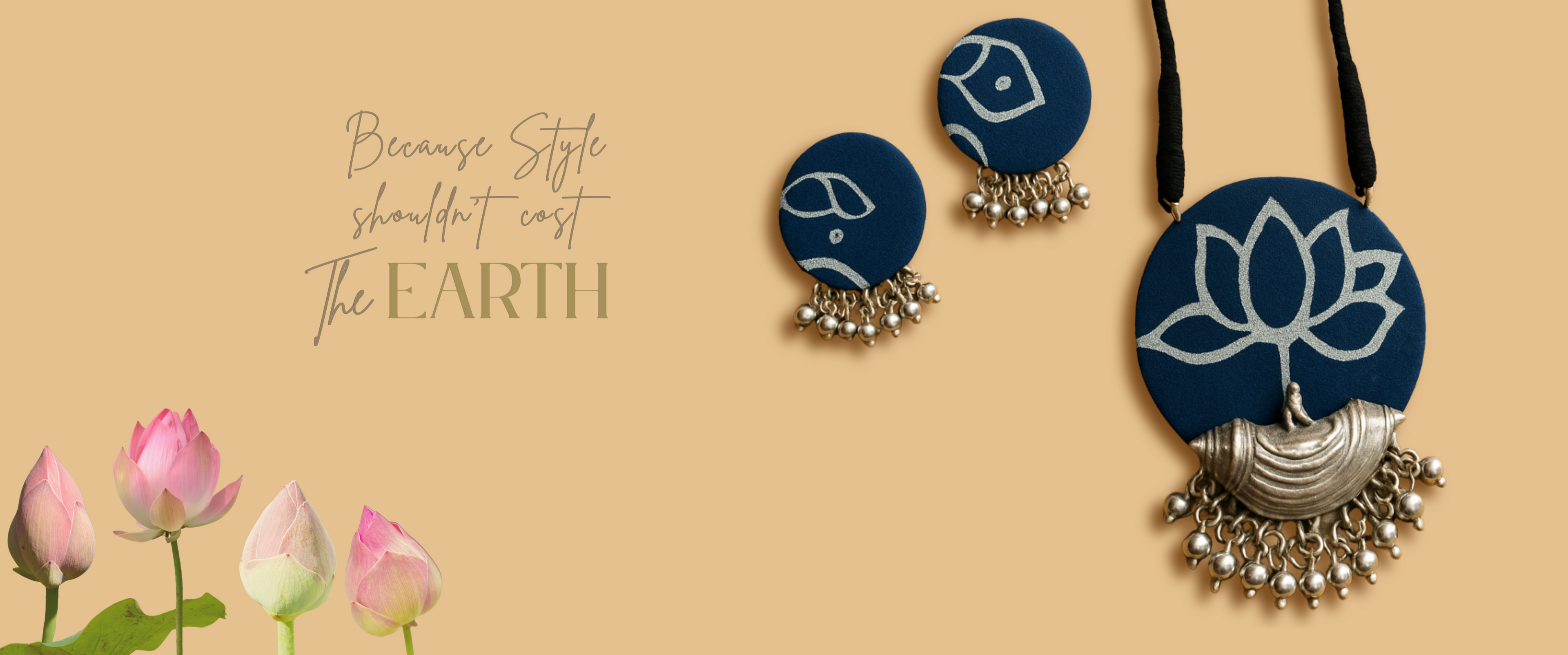 Navy blue lotus-themed earrings and necklace on a beige background with pink lotus flowers. Sustainable Fashion jewellery by organic Vibes